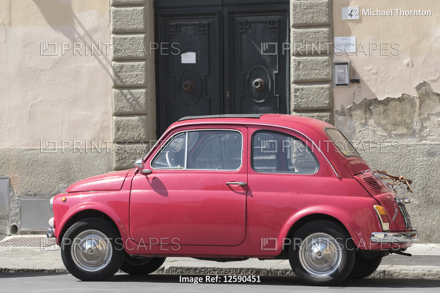 Old red car, Fiat, parked on street outside doorway, Pisa. Tuscany; Italy; ...
