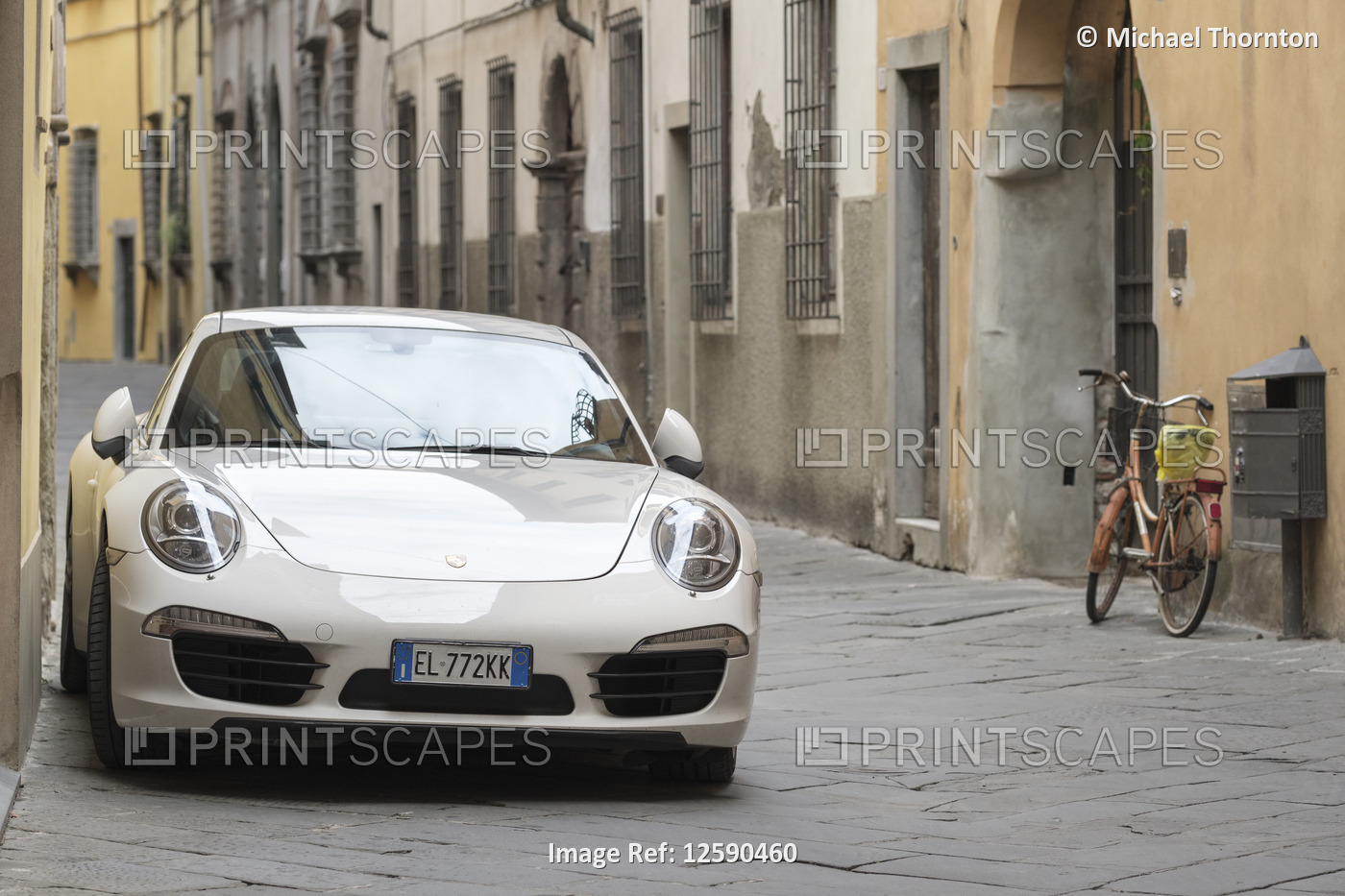 The Porsche 911 Carrera and the bicycle, old city street of Lucca, Tuscany, ...