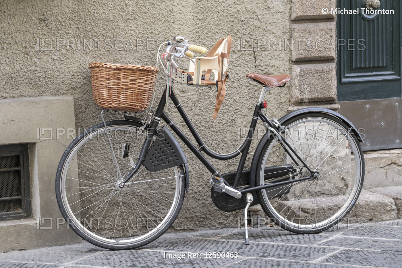 Bicycle with basket and childs seat, old city street in Lucca, Tuscany, Italy, ...