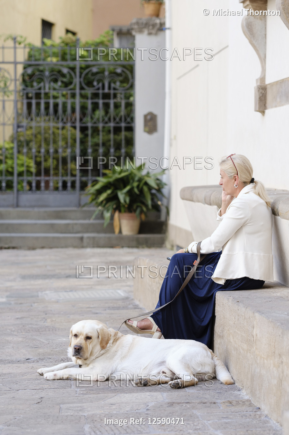 Woman and dog sitting relaxing in the Piazza San Martino, Lucca, Tuscany, ...