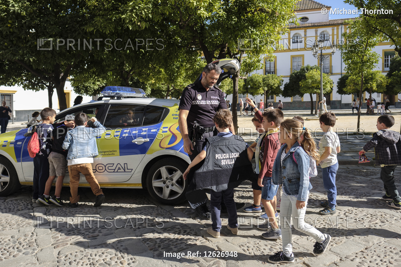Police officer giving young children a tour of the police car, Patio de ...