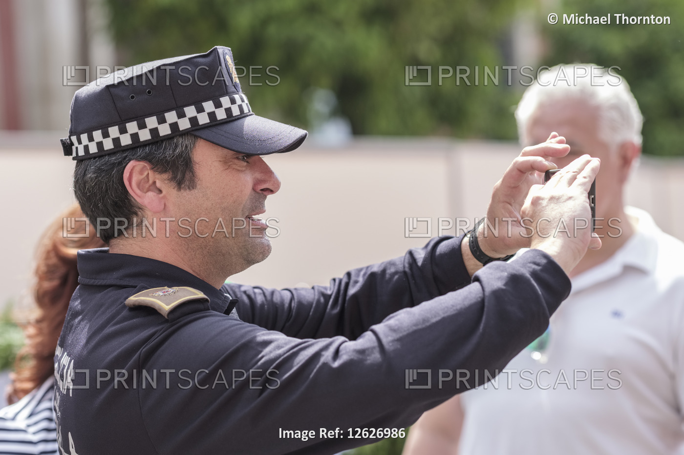Policeman taking photograph for tourists, Spain,