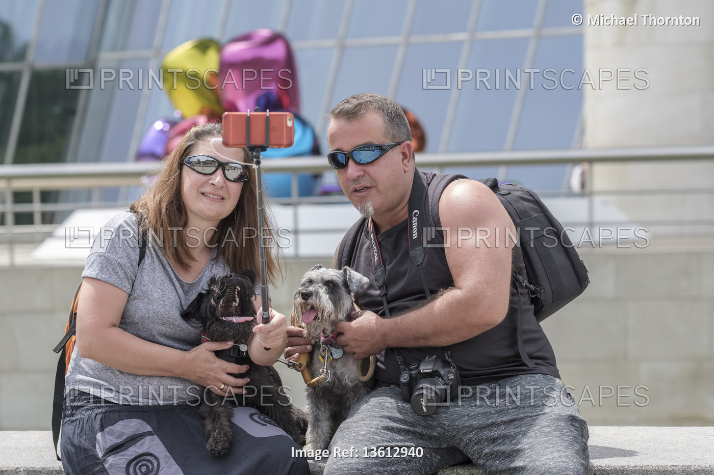 Couple taking Selfie with their family pet dog, outside the Guggenheim Musuem, ...