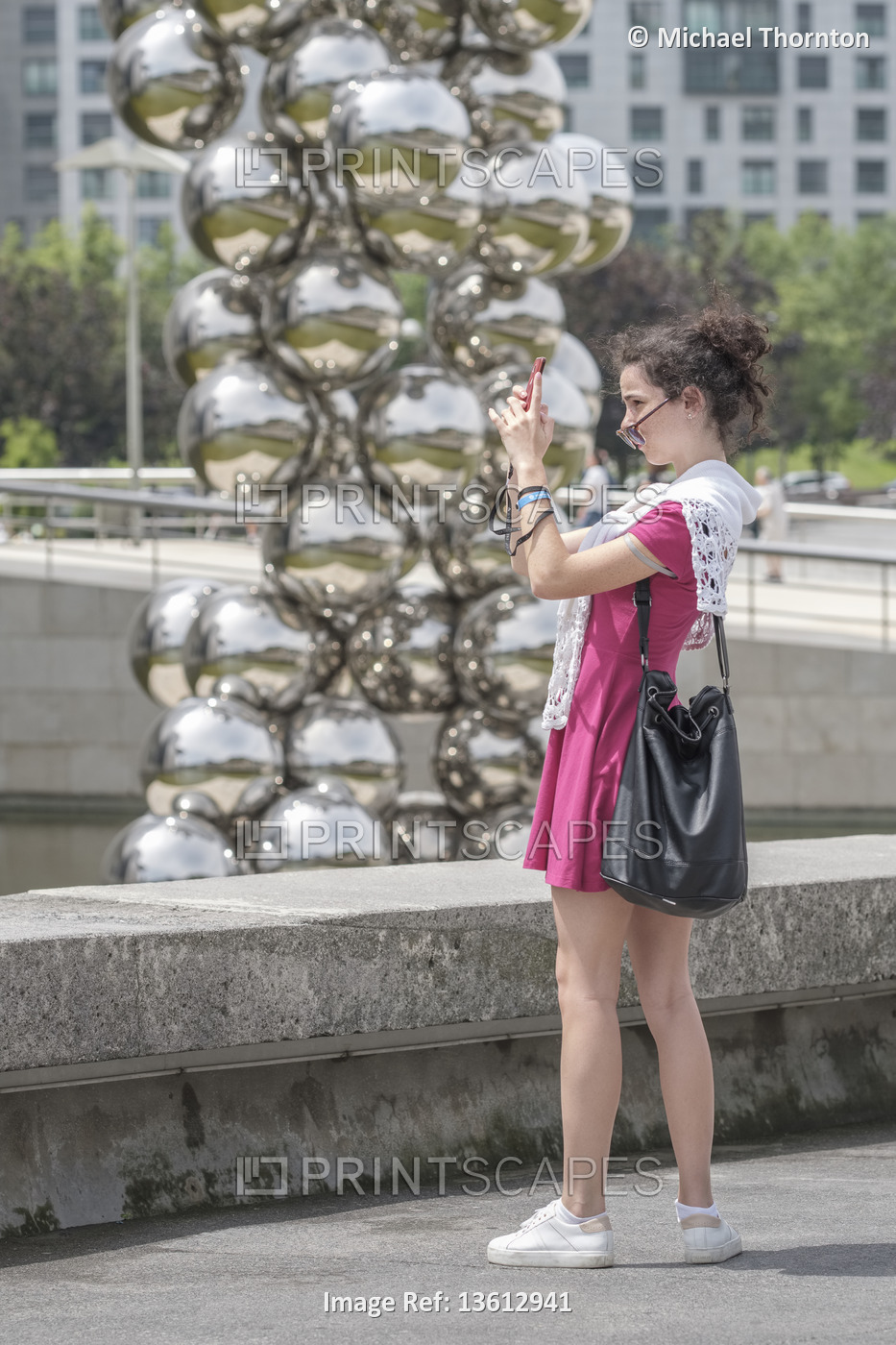 Young lady taking a selfie outside the Silver Balls sculpture of the Guggenheim ...