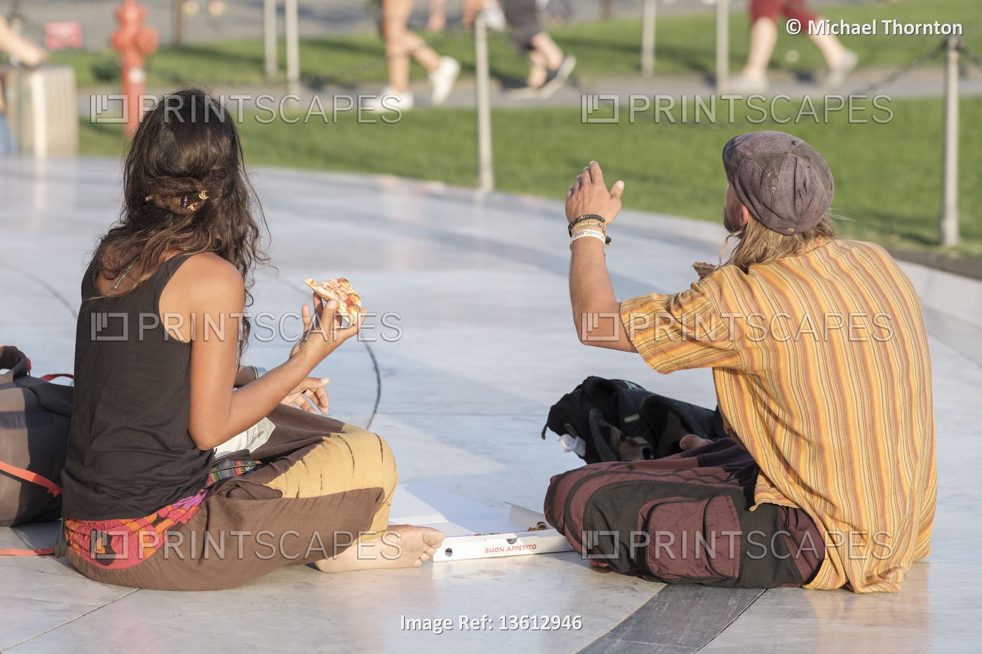 couple sitting enjoying a pizza in the Piazza dei Miracoli, Pisa, Tuscany, ...