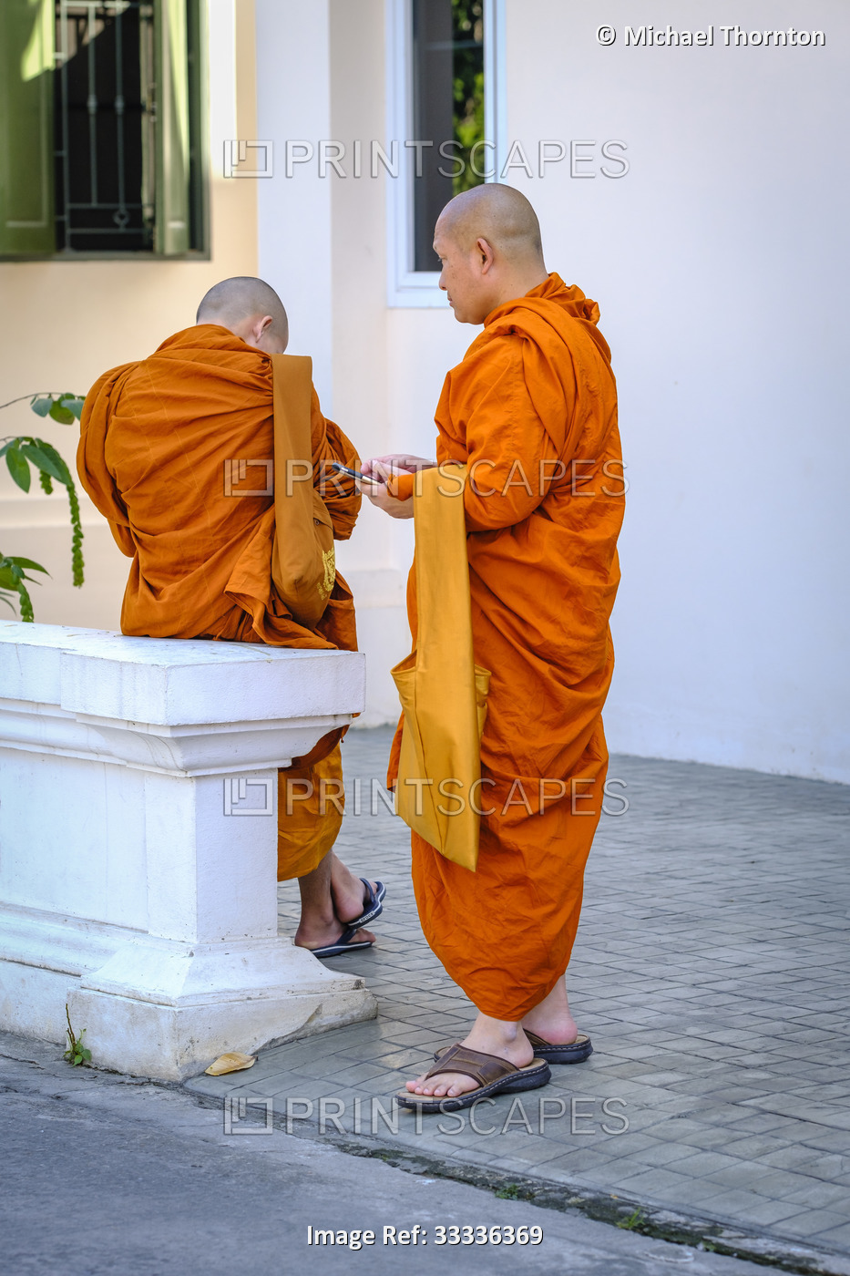 Two monks chatting at Wat Phra That Chedi Luang, Thailand,
