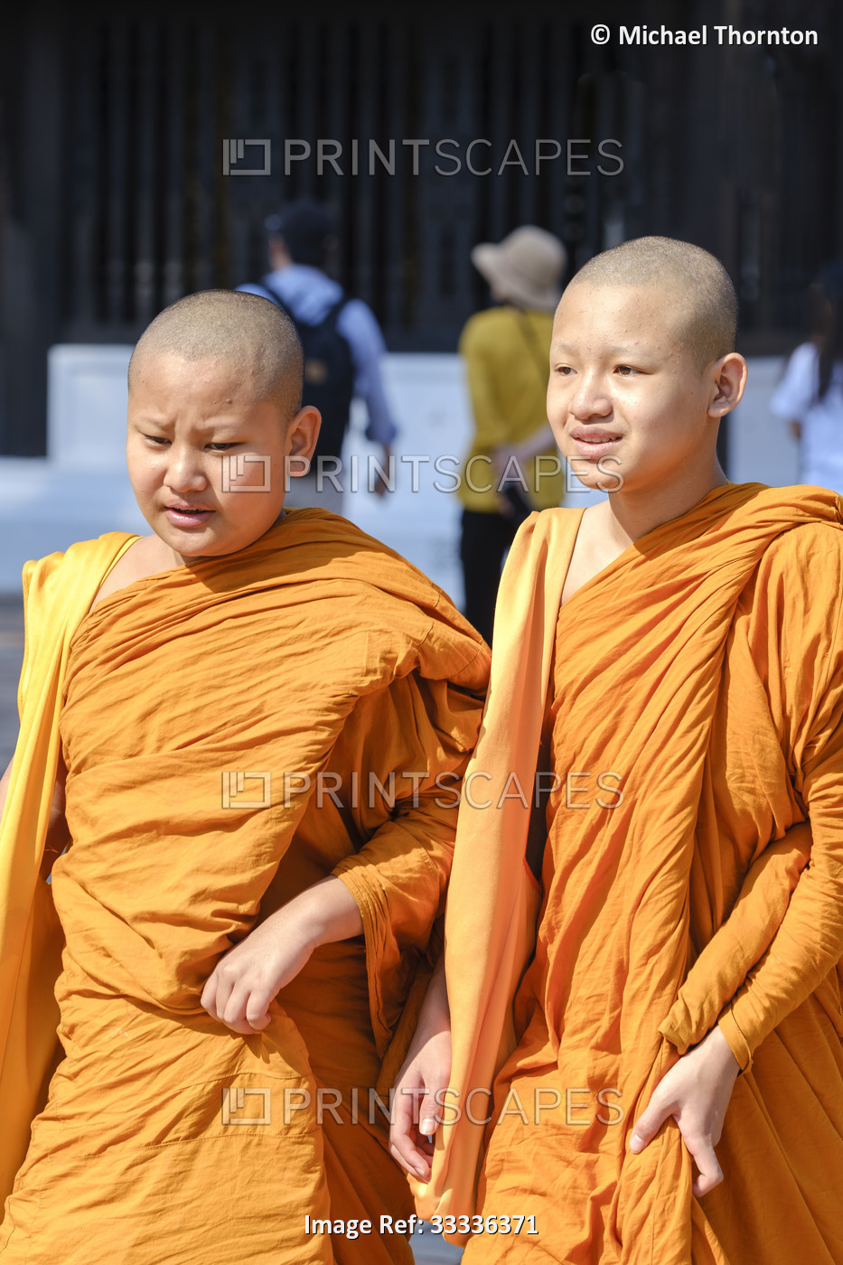 Two young novice monks walking at Wat Phra That Chedi Luang, Thailand,